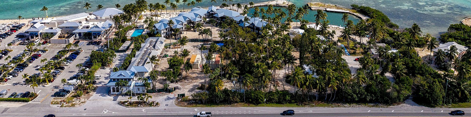 A coastal area with turquoise waters, a line of buildings, palm trees, and a road with vehicles under a cloudy sky ends the scene.
